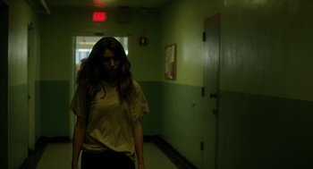 Movie still from “Side Effects” (2013), directed by Steven Soderbergh – A woman standing in the hallway of a building; Medium shot, Low angle