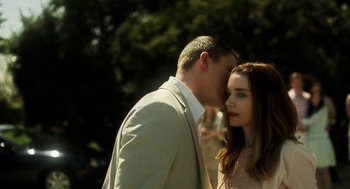 Movie still from “Side Effects” (2013), directed by Steven Soderbergh – A man and a woman standing next to each other in front of trees; Close Up shot, Over the shoulder angle