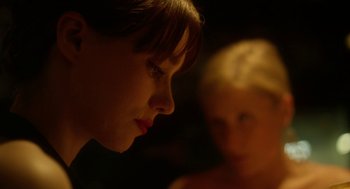 Movie still from “Side Effects” (2013), directed by Steven Soderbergh – A young woman looking at the camera with a young child in the background; Close Up shot, Over the shoulder angle