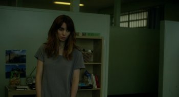 Movie still from “Side Effects” (2013), directed by Steven Soderbergh – A woman standing in front of a book shelf; Medium shot, Over the shoulder angle