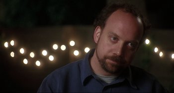 Movie still from “Sideways” (2004), directed by Alexander Payne – A person wearing a blue shirt with lights in the background; Close Up shot, Over the shoulder angle