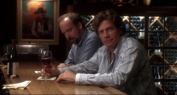 Movie still from “Sideways” (2004), directed by Alexander Payne – A couple of men sitting at a table next to a glass of red wine; Medium shot, Over the shoulder angle