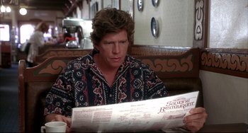Movie still from “Sideways” (2004), directed by Alexander Payne – A man sitting at a table reading a newspaper; Medium shot, Over the shoulder angle