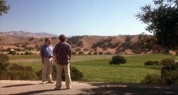 Movie still from “Sideways” (2004), directed by Alexander Payne – Two men standing on the side of the road looking out at a field; Extreme Wide shot, Over the shoulder angle