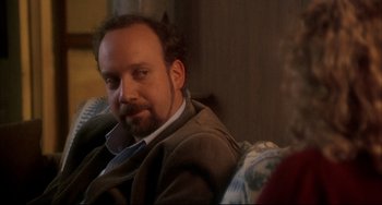 Movie still from “Sideways” (2004), directed by Alexander Payne – A man sitting on a couch in a living room; Close Up shot, Over the shoulder angle