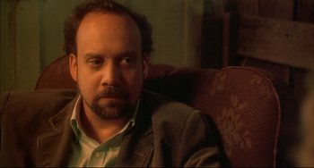 Movie still from “Sideways” (2004), directed by Alexander Payne – A person sitting in a chair wearing a suit; Close Up shot, Over the shoulder angle