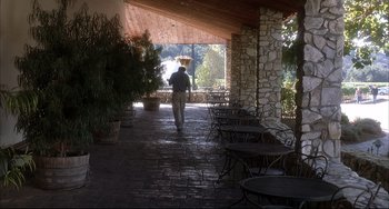 Movie still from “Sideways” (2004), directed by Alexander Payne – A man walking down a stone walkway carrying a basket of food; Wide shot, High angle