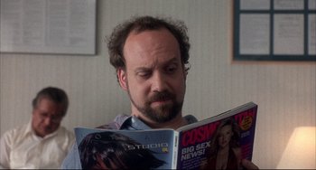 Movie still from “Sideways” (2004), directed by Alexander Payne – A man with a beard reading a magazine; Close Up shot, Over the shoulder angle