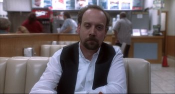 Movie still from “Sideways” (2004), directed by Alexander Payne – A man sitting on a couch in a restaurant; Close Up shot, Over the shoulder angle