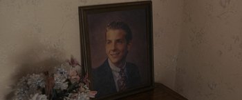 Movie still from “Silver Linings Playbook” (2012), directed by David O. Russell – A picture of a young man in a suit and tie; Extreme Close Up shot, High angle