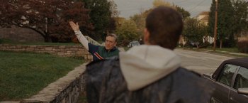 Movie still from “Silver Linings Playbook” (2012), directed by David O. Russell – A man is waving at another man on the side of the road; Medium shot, Over the shoulder angle