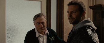 Movie still from “Silver Linings Playbook” (2012), directed by David O. Russell – Two men standing next to each other in front of a wall; Close Up shot, Over the shoulder angle