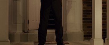 Movie still from “Silver Linings Playbook” (2012), directed by David O. Russell – A man standing in front of a door way; Medium shot, Low angle