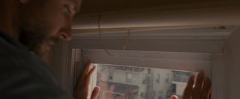 Movie still from “Silver Linings Playbook” (2012), directed by David O. Russell – A person looking out of a window at a street; Extreme Close Up shot, Low angle