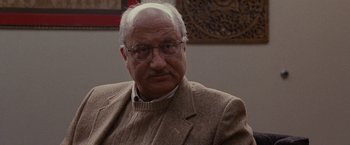 Movie still from “Silver Linings Playbook” (2012), directed by David O. Russell – An older man wearing glasses and a jacket; Close Up shot, Over the shoulder angle