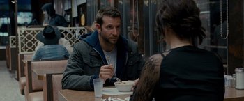 Movie still from “Silver Linings Playbook” (2012), directed by David O. Russell – A man and a woman sitting at a dinner table; Medium shot, Over the shoulder angle