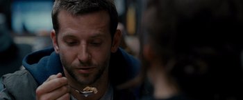 Movie still from “Silver Linings Playbook” (2012), directed by David O. Russell – A person with a piece of food in his mouth; Close Up shot, Over the shoulder angle