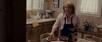 Movie still from “Silver Linings Playbook” (2012), directed by David O. Russell – A woman in a kitchen preparing food on a table; Medium shot, Over the shoulder angle