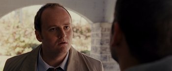 Movie still from “Silver Linings Playbook” (2012), directed by David O. Russell – A man wearing a suit and tie talking to another man wearing a suit and tie; Close Up shot, Over the shoulder angle