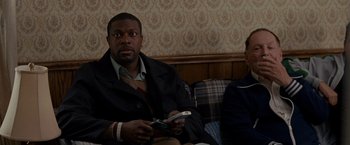 Movie still from “Silver Linings Playbook” (2012), directed by David O. Russell – A man and a woman sitting on a couch holding cell phones; Medium shot, High angle