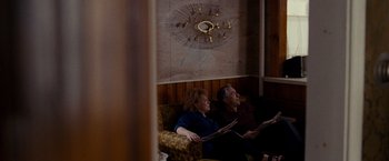 Movie still from “Silver Linings Playbook” (2012), directed by David O. Russell – A man and a woman sitting on a couch reading newspapers; Wide shot, High angle