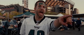 Movie still from “Silver Linings Playbook” (2012), directed by David O. Russell – A man in a eagles jersey is yelling at the camera; Close Up shot, Over the shoulder angle