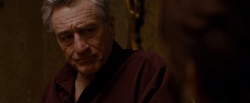 Movie still from “Silver Linings Playbook” (2012), directed by David O. Russell – An older man wearing a red shirt and a gold chain; Close Up shot, Over the shoulder angle