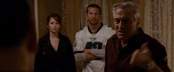 Movie still from “Silver Linings Playbook” (2012), directed by David O. Russell – A group of people standing in front of a man; Medium shot, Over the shoulder angle