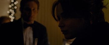 Movie still from “Silver Linings Playbook” (2012), directed by David O. Russell – A woman is looking at the camera while a man is sitting at a table; Close Up shot, Over the shoulder angle