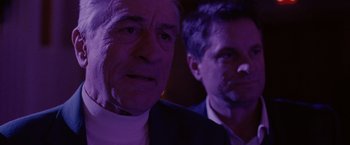 Movie still from “Silver Linings Playbook” (2012), directed by David O. Russell – Two men in a dark room , one of whom is looking at the camera and the other is looking at the camera; Close Up shot, Over the shoulder angle