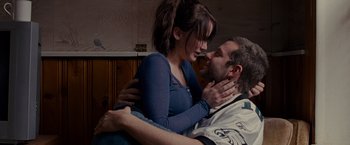 Movie still from “Silver Linings Playbook” (2012), directed by David O. Russell – A man and a woman are kissing in a room; Medium shot, Over the shoulder angle