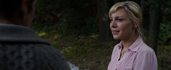Movie still from “Sinister” (2012), directed by Scott Derrickson – A woman standing in the woods near a tree; Close Up shot, Over the shoulder angle