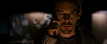 Movie still from “Sinister” (2012), directed by Scott Derrickson – A person talking on a cell phone; Close Up shot, Low angle