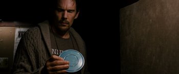 Movie still from “Sinister” (2012), directed by Scott Derrickson – A person holding a frisbee; Close Up shot, Overhead angle