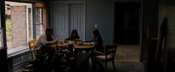 Movie still from “Sinister” (2012), directed by Scott Derrickson – A group of people sitting at a table eating food; Wide shot, High angle
