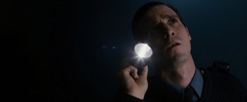 Movie still from “Sinister” (2012), directed by Scott Derrickson – A man is holding a flashlight in his hand; Close Up shot, Low angle
