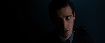Movie still from “Sinister” (2012), directed by Scott Derrickson – A person wearing a suit and tie; Close Up shot, Low angle