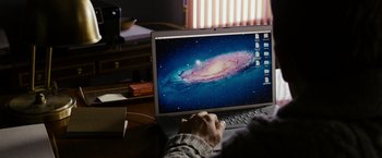 Movie still from “Sinister” (2012), directed by Scott Derrickson – A person using a laptop computer on a desk; Medium shot, High angle