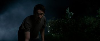 Movie still from “Sinister” (2012), directed by Scott Derrickson – A man is standing in the dark with his hands on his hips; Medium shot, Low angle
