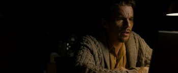 Movie still from “Sinister” (2012), directed by Scott Derrickson – A person sitting in a chair wearing a sweater; Close Up shot, Low angle