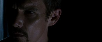 Movie still from “Sinister” (2012), directed by Scott Derrickson – A person's ear with a dark background; Extreme Close Up shot, Low angle