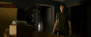 Movie still from “Sinister” (2012), directed by Scott Derrickson – A man standing in front of a mirror holding a baseball bat; Medium shot, Low angle