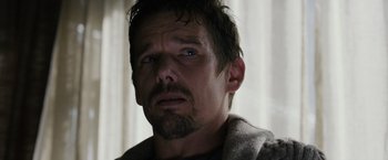 Movie still from “Sinister” (2012), directed by Scott Derrickson – A person with a beard looking at the camera; Close Up shot, Over the shoulder angle
