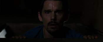 Movie still from “Sinister” (2012), directed by Scott Derrickson – A person looking at the camera; Close Up shot, Low angle
