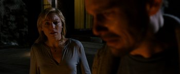 Movie still from “Sinister” (2012), directed by Scott Derrickson – A woman standing next to a man in front of a window; Close Up shot, Over the shoulder angle