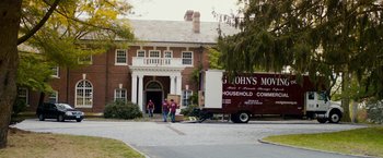 Movie still from “Sinister” (2012), directed by Scott Derrickson – Three men unloading boxes from a moving truck outside of a house; Wide shot, High angle