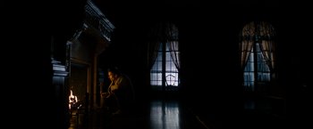 Movie still from “Sinister” (2012), directed by Scott Derrickson – A woman sitting on the floor in front of a window; Wide shot, Low angle