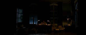 Movie still from “Sinister” (2012), directed by Scott Derrickson – A person sitting at a desk with a laptop; Extreme Wide shot, High angle