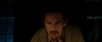 Movie still from “Sinister” (2012), directed by Scott Derrickson – A person wearing a jacket; Close Up shot, High angle