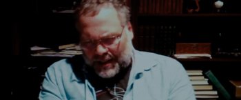 Movie still from “Sinister” (2012), directed by Scott Derrickson – An older man wearing glasses and a tie; Close Up shot, High angle